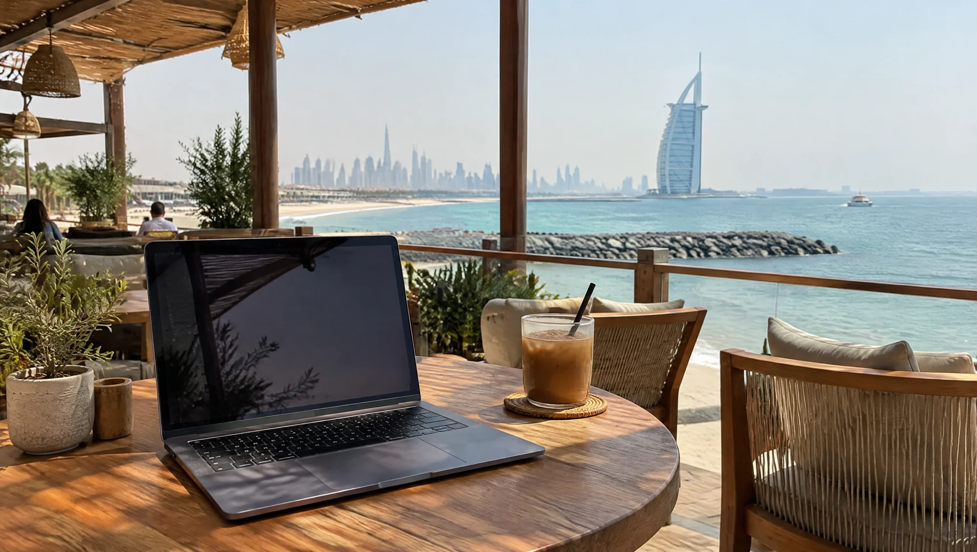 Portátil en la terraza de un café junto al mar en los EAU